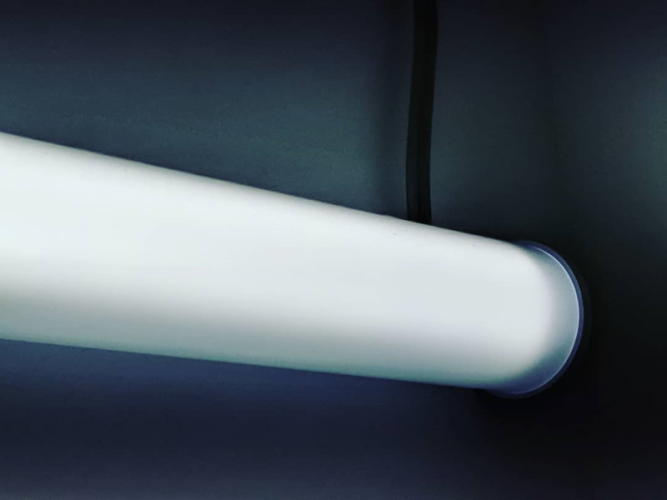 a cylindrical fluorescent light mounted to a wall
